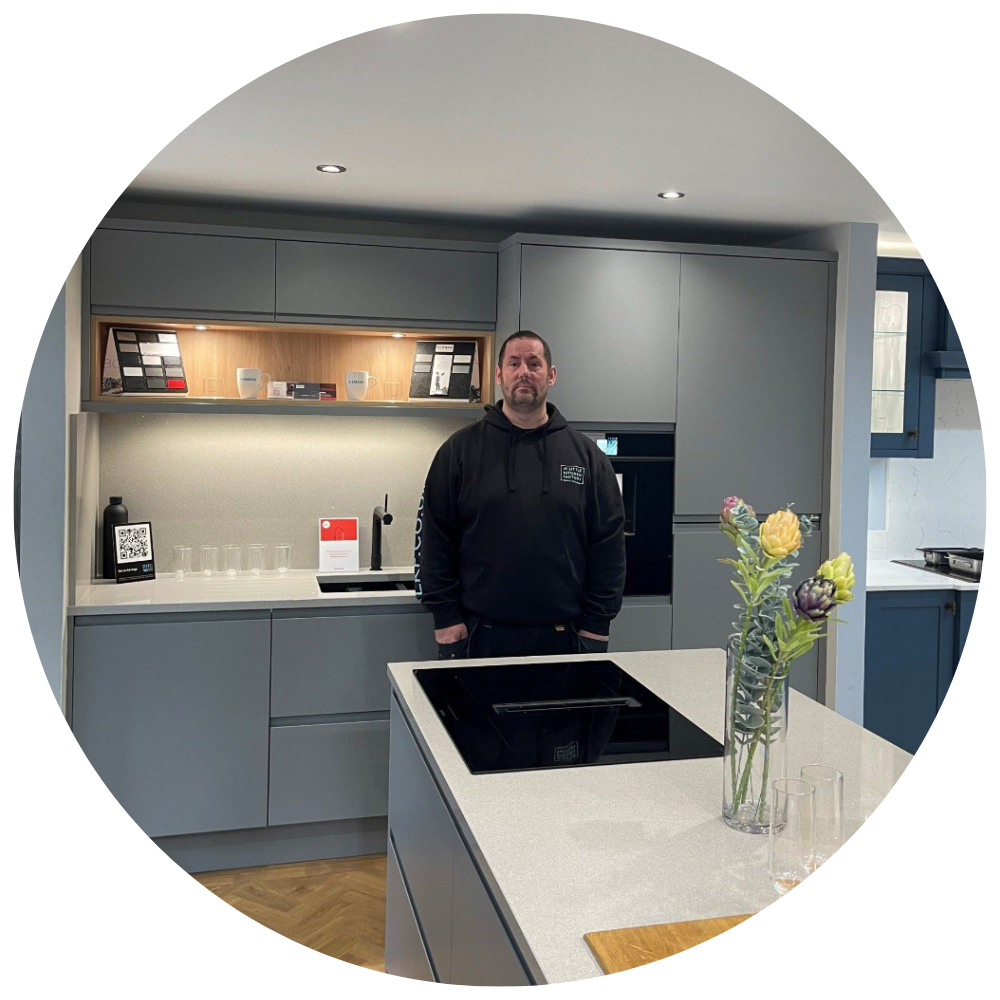 Chris Brown | The Little Kitchen Factory Team Chris Brown from The Little Kitchen Factory standing in a grey kitchen showroom
