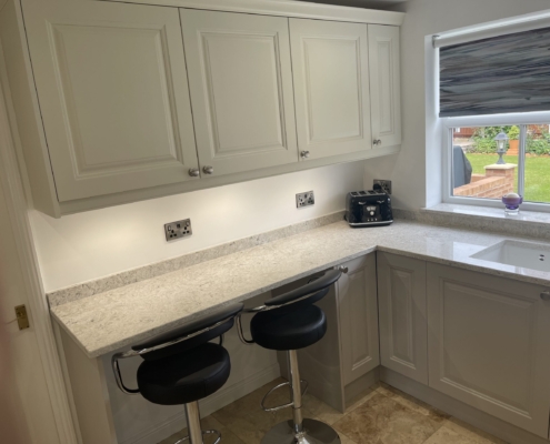 Jefferson cashmere kitchen with Fugen Irini quartz worktops, breakfast bar and garden view