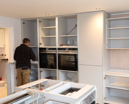 Bespoke kitchen fitting - cabinetry and built-in ovens being installed in a client home