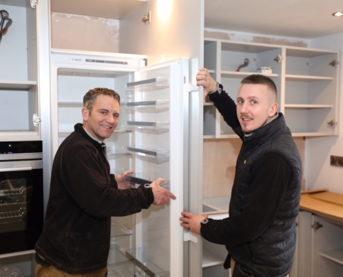 TLKF installation team fitting a built-in fridge in a client kitchen